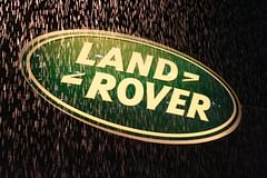 land rover sign behind a waterfall